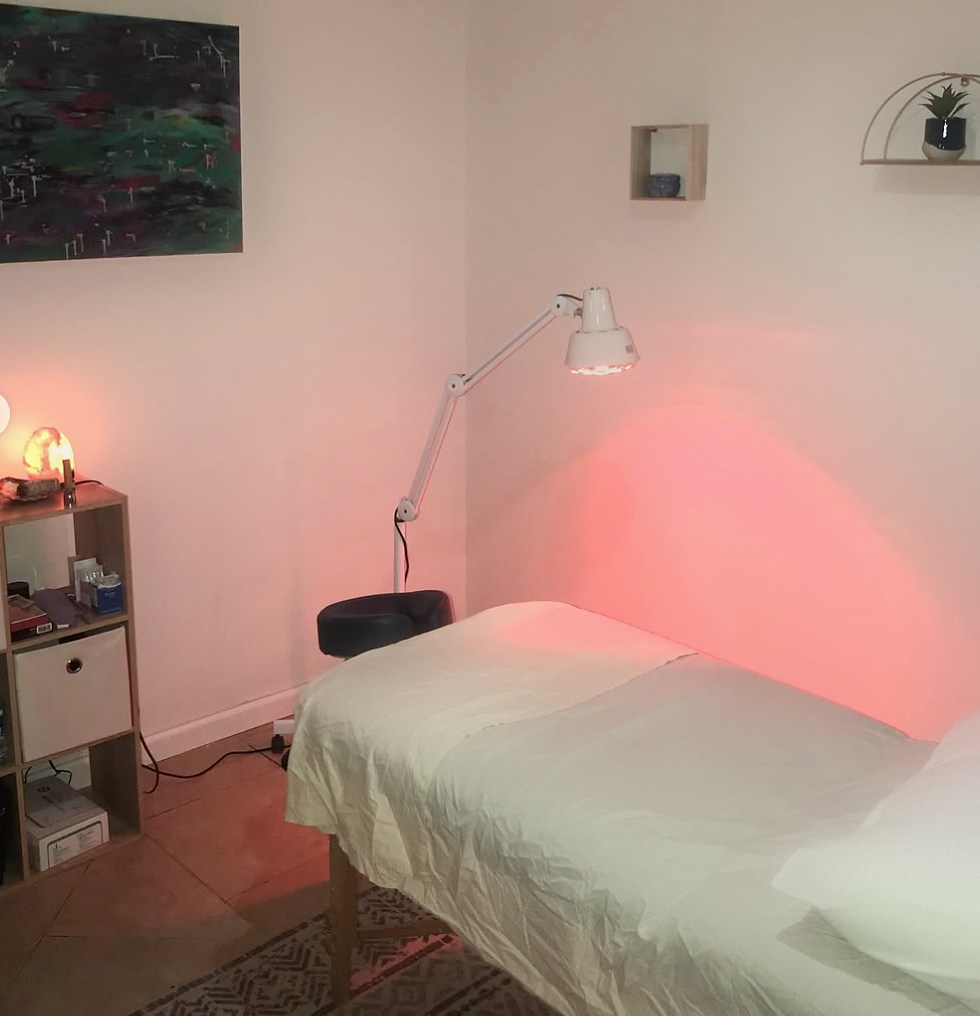 Sano treatment room with warming heat lamp and massage table